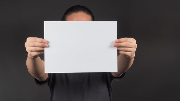 Male model's hands is holding blank A4 paper on black background. photo
