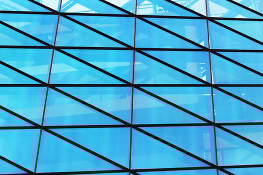 Glass window wall of modern building with blue sky reflection photo