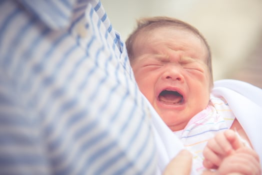Baby crying in mother embrace. Newborn and infant healthy concept. Birthday and love of mother theme photo