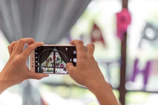 A man is taking pictures with a mobile phone in his hand photo