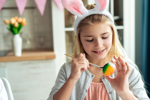 Closeup little girl draws an easter egg. photo