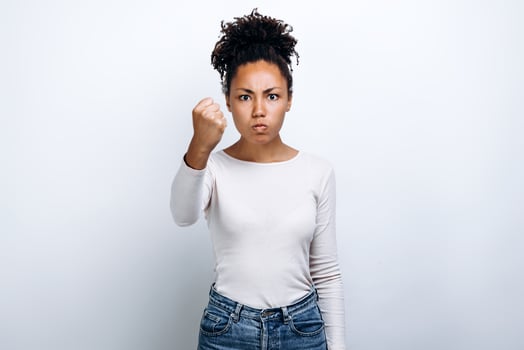 Young girl on white background shows his fist. Female force. photo