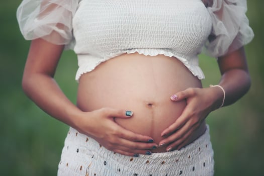 happy and proud pregnant Asian woman looking at her belly photo