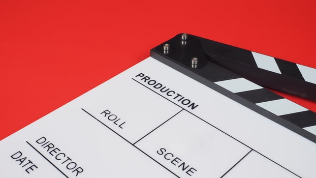 Clapperboard or movie slate. it use in video production ,film, cinema industry on red background. photo