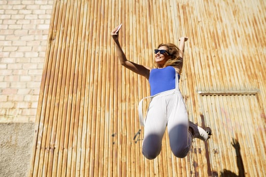 Girl jumping while making a selfie with her smartphone. photo