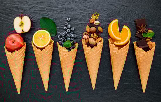 Various of ingredient for ice cream flavor in cones set up on dark stone background . Summer and Sweet menu concept. photo