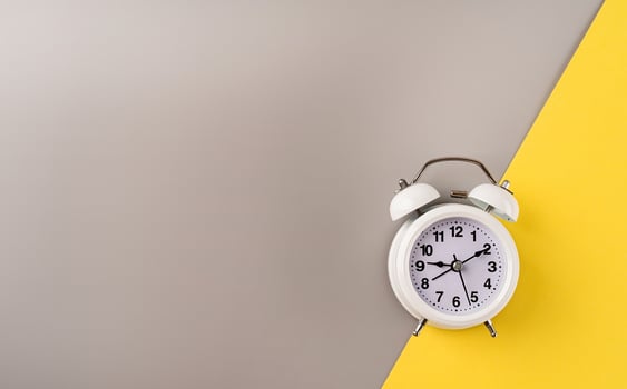 White retro alarm clock isolated on double yellow and gray background with copy space photo