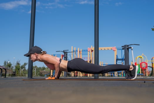 Sportive woman working out on the sports ground in sunny summer day photo