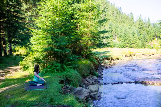 Woman do yoga at river beach photo