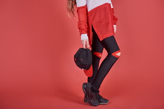 Young beautiful cute girl dancing on red background, modern slim hip-hop style teenage girl jumping photo
