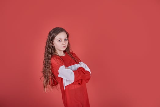 Young beautiful cute girl dancing on red background, modern slim hip-hop style teenage girl jumping photo