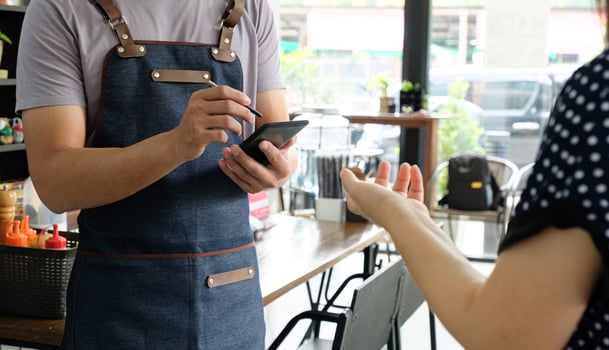 Employee holding a smartphone to save the menu the customer order. photo