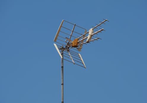 Tv antenna over blue sky with copy space photo