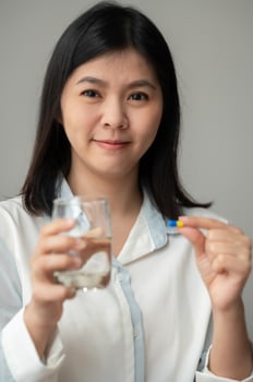 Woman taking supplement pill photo