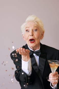 short hair stylish senior woman in tuxedo with glitter celebrating new year. Fun, lifestyle, style, age concept photo