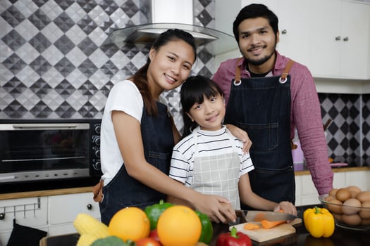 Happy Family have Dad, Mom and their little daughter Cooking Together in the Kitchen photo
