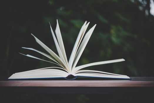 Open book on wooden table outdoors photo