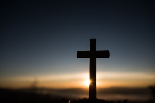 Silhouette of catholic cross and sunrise photo