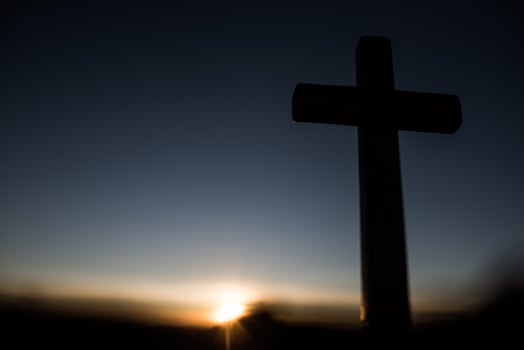 Silhouette of catholic cross and sunrise photo