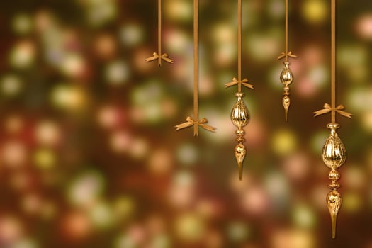 Gold Christmas Ornaments on a Blurry Lit Background photo