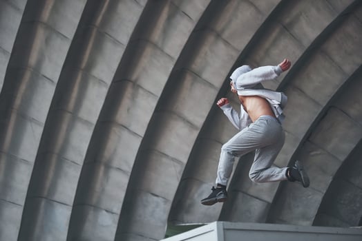 A young man is jumping. Parkour in urban space, sporting activity. photo