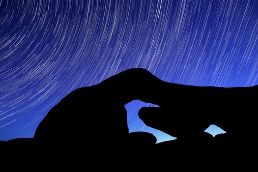 Night Star Trail Streaks over the Rocks of Joshua Tree Park photo