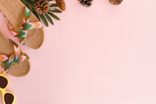 Creative flat lay photo of travel vacation spring or summer tropical fashion. Top view beach accessories on pastel pink color background with blank space for text. Top view copy space photography.