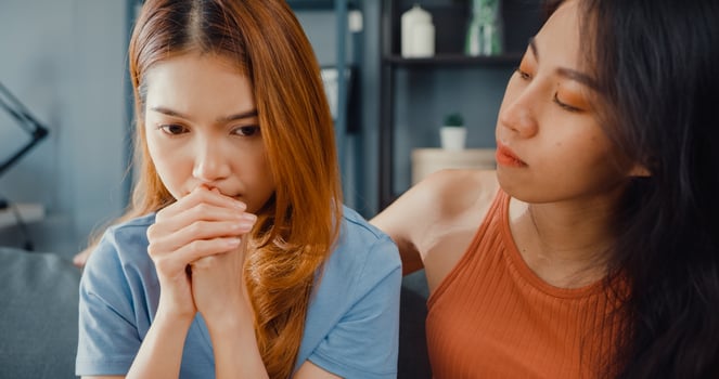Asian women teenager embracing to calm her sad best friends from feeling down from breakup with boyfriend in living room at home. Friendship counseling and care, unhappy girl support her girlfriend. photo