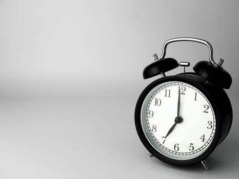 Alarm Clock isolated on white, in black with shadow, showing seven o'clock photo
