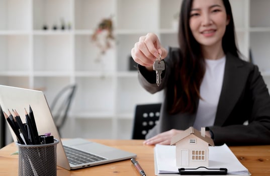 Close up focus on keys, smiling woman realtor selling apartment, offering to client, showing at camera, holding documents, contract, making purchasing deal, real estate agent, mortgage or rent photo
