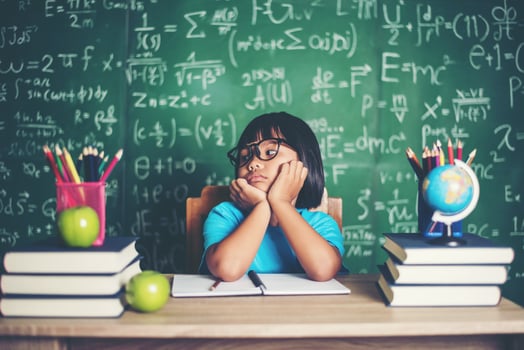 Thoughtful little girl with book near a school board photo