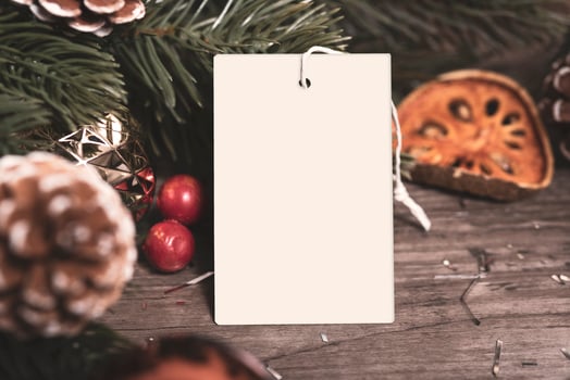 mockup tag paper card with pine cones christmas decoration on wood table background. photo