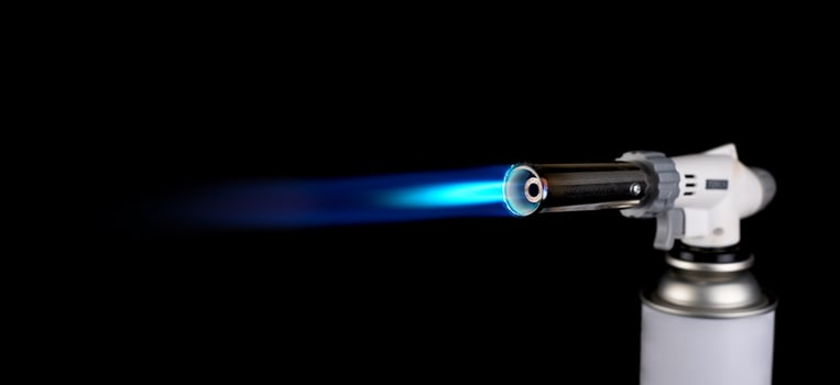 Gas burner with fire flame at black background photo