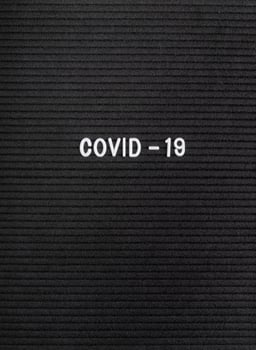 The words Covid-19 on black felt letter board photo