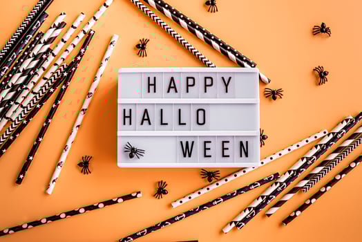 happy halloween cinema lightbox with spiders and black and white drinking straws top view on orange background photo