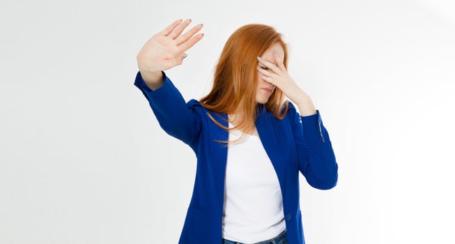 Young red hair woman making a rejection pose and facepalm on a white background. Negative human emotion face expression feeling body language photo
