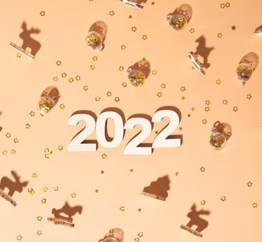 Festive new year flat lay with numbers 2022 and hard shadows with glasses and shiny decor photo