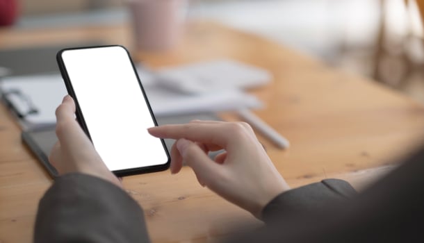 Top view Woman sitting and holding blank screen mock up mobile phone photo