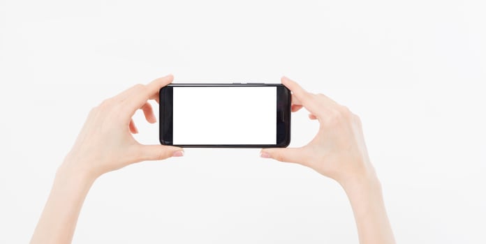 hand holding mobile phone gorizontal isolated on white background,empty blank screen photo