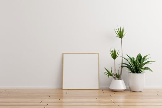 Square wooden photo frame mockup on white wall empty room with plants on a wooden floor