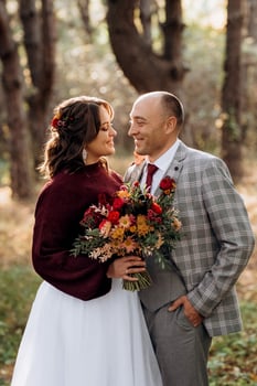 walk of the bride and groom through the autumn forest photo