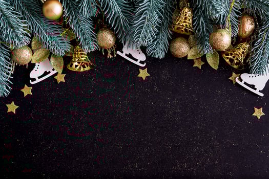 Top view Merry Christmas black background decorated with Happy New Year Christmas tree branches, stars, bells and baubles with copy space. Winter holiday card decoration festive fun concept, flat lay. photo