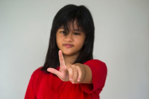 A beautiful young girl pinting with her index finger photo