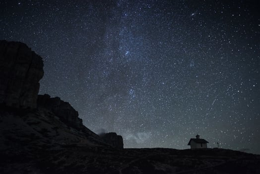Milky way on the horizon. View from mountain with small building on it photo