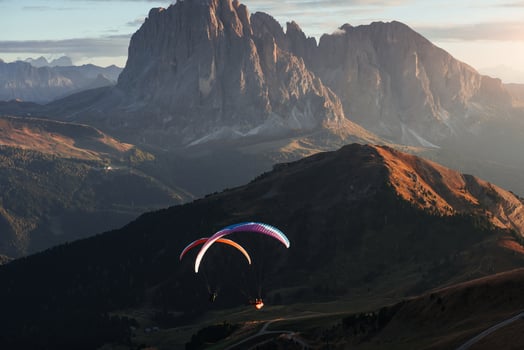 The Seceda dolomites and two paragliders on the sunset lights photo