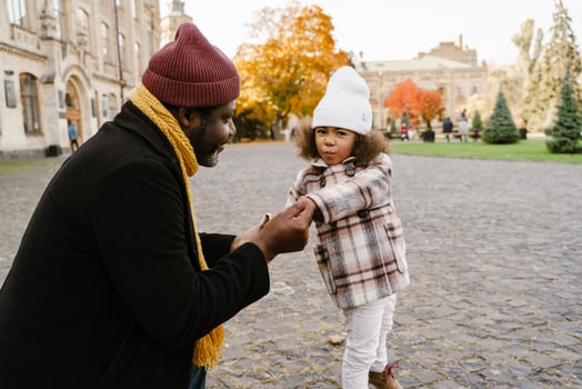 Black grandfather talking with his granddaughter and walking outdoors photo