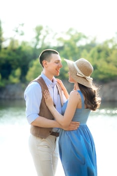 a young couple a guy and a girl are walking near a mountain lake surrounded photo