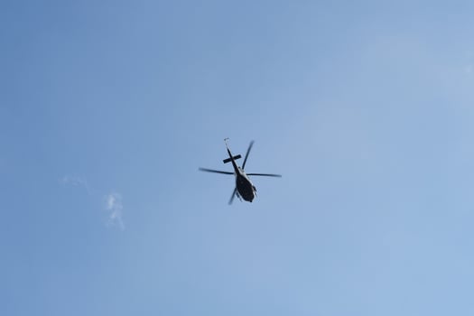 On the azure sky, a helicopter flies. photo