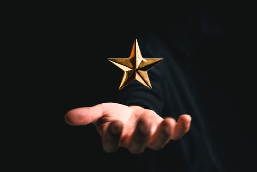 golden star rating on hand in dark background photo