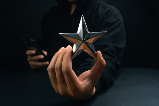 golden star rating on hand in dark background photo